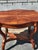 Beautiful vintage wooden side table featuring an elegant, decorative design with a warm reddish-brown wood finish. The...