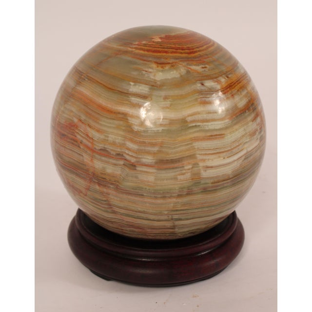 Large onyx orb on a wood stand. Probably shaped approximately 50 years ago.
