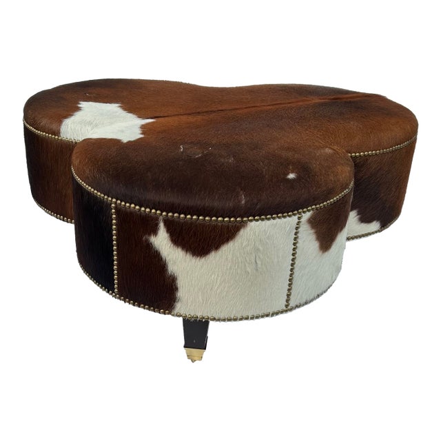 Vintage Cloverleaf Cowhide Ottoman With Brass Casters & Nailhead Trim For Sale