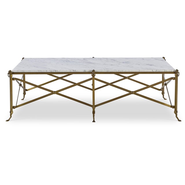 The French midcentury brass cocktail table with lion detail and paw feet, featuring a neoclassical X-base, illustrates the...
