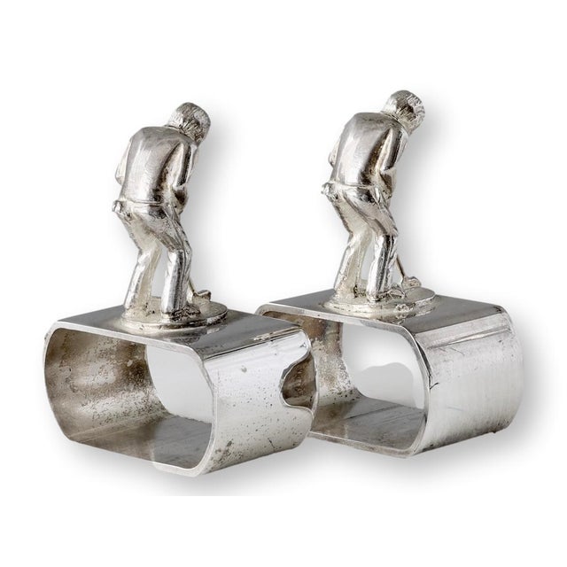 Whimsical pair of mid-century English silverplate napkin rings, each topped with a finely detailed golfer in mid-swing. A...