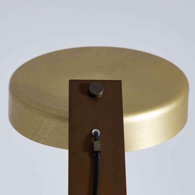 Desk lamp with a brown painted metal frame and a gold aluminum shade that matches other details of the lamp. The shade is...