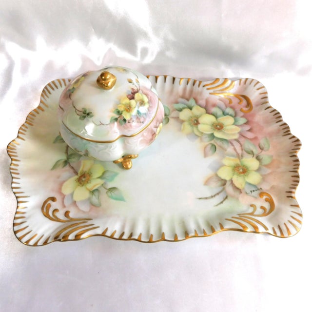 This is a hand painted and signed vanity tray plus a matching footed, covered, vanity jar hand that is also hand painted...