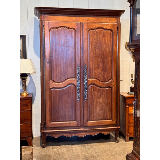 An 18th century Louis XV provincial armoire, the two shaped raised-panel doors with long pierced steel escutcheons and a...