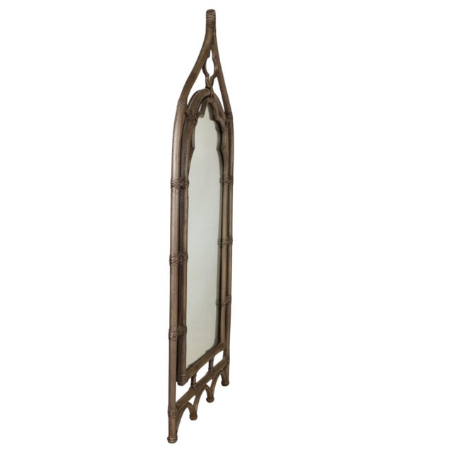 A mid-century gothic style McGuire of San Francisco rattan and leather mirror. The mirror features an arched form and...
