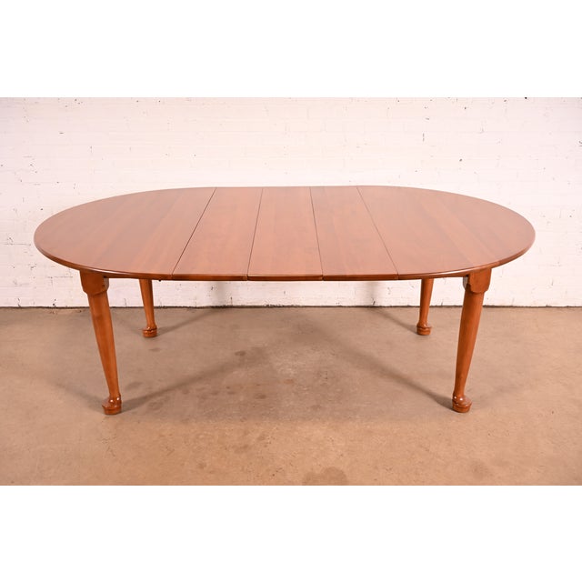A gorgeous mid-century American Colonial or Queen Anne style solid cherry wood extension dining table By L. & J.G....