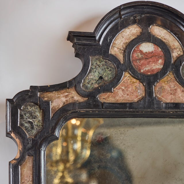 Hand-carved, ebonized with marble veneer inset, framed mirror. Original glass.