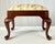 Queen Anne style footstool by fine furniture maker Henkel Harris. This stool features a solid mahogany frame with a rich,...