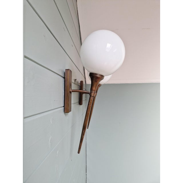 Pair of Art Deco brass wall sconces with white opaline glass globes, 1930s. Each sconce has been restored and rewired and...