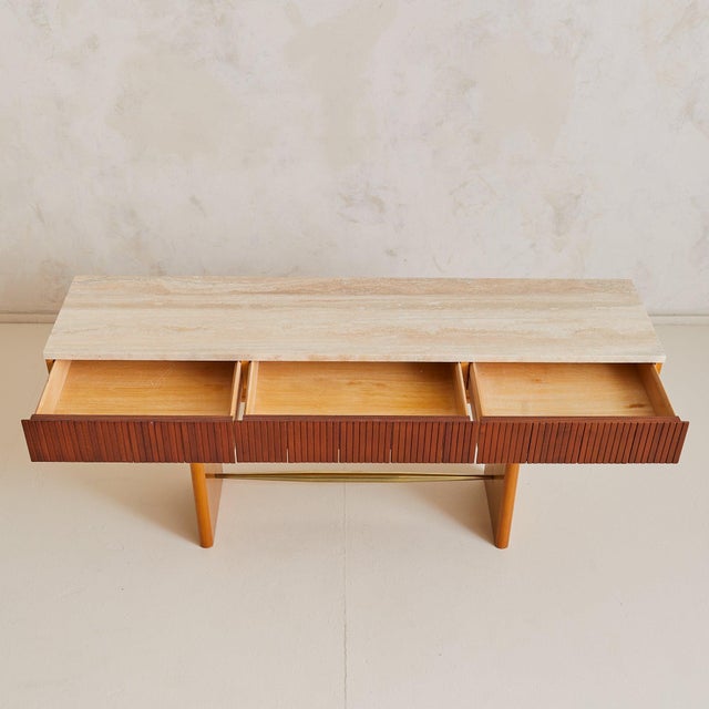An Italian console table from the 1970s, defined by clean architectural lines and a refined material palette. The...