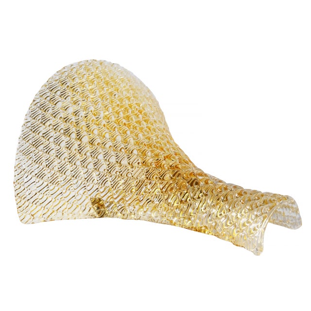 Pair of wall light sconces handmade in Murano glass with brass details. Glass is yellow colour and relief pattern. Bulbs...