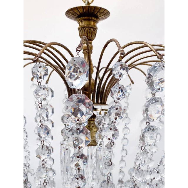 Parachute chandelier with brass wired dome, octagon chain, graduated chain and 30% leaded U-drop crystals. It has an...