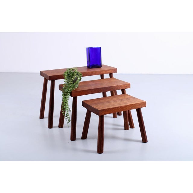 A set of three teak ( colored ) nesting tables. Robust appearance with no decorative elements, just an honest focus on the...