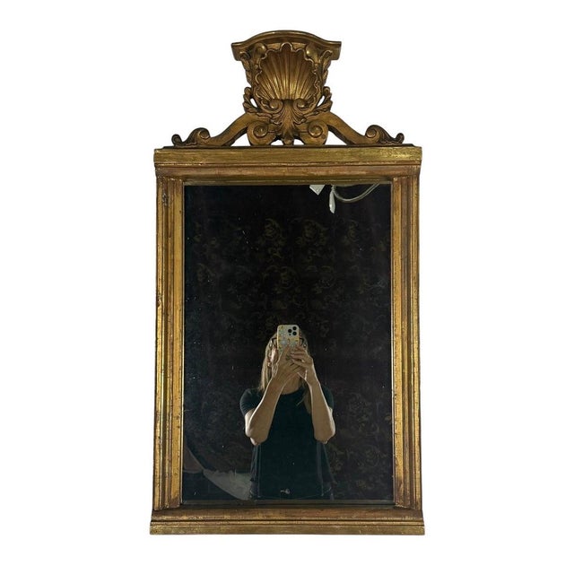 A finely carved 19th century Italian giltwood mirror, featuring a bold crest surmounted with a scallop shell cartouche...