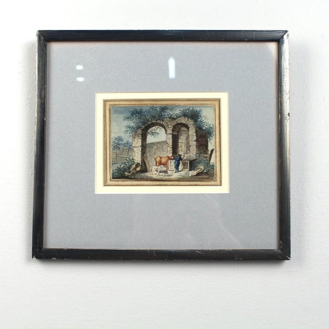 Offered here for your consideration is an antique watercolor painting on laid paper. It depicts a cowherd with a cow and...