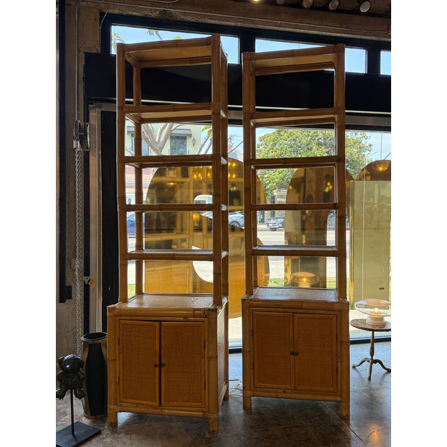 A stylish pair of Italian mid-century étagère bookcases crafted from natural bamboo with woven rattan accents, dating to...