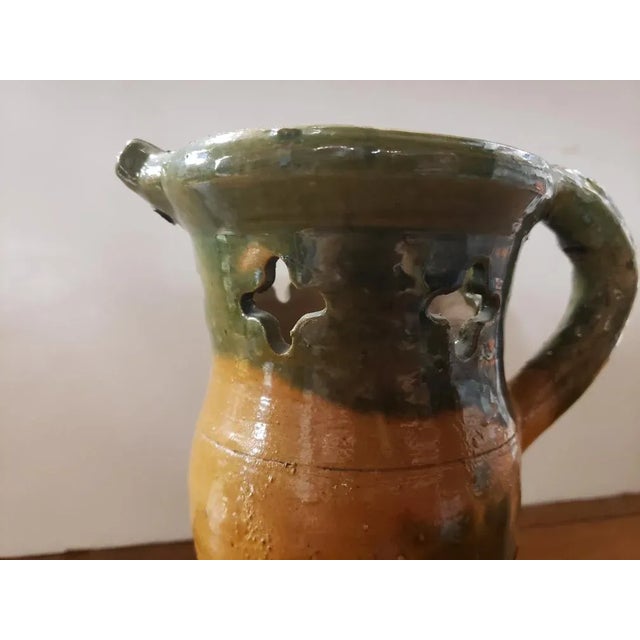 This 1930's/1940's Clay Puzzle Jug measures 8 1/4" high, 7" wide and 4 1/2" deep.