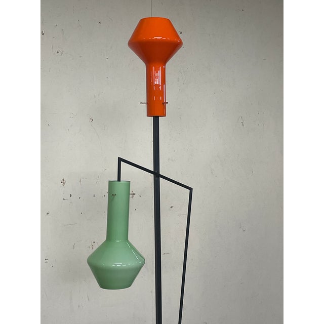 A 1950s floor lamp produced by Vetreria Laguna Murano. It stands out for its minimalist black lacquered iron frame with...