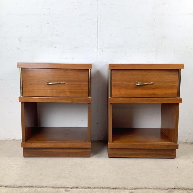 This pair of mid-century modern nightstands balances clean architectural lines with warm walnut tones and subtle brass...