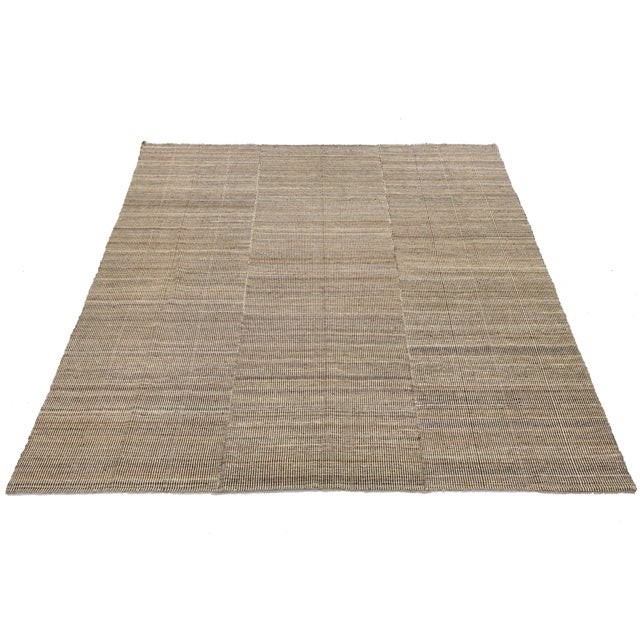 This Modern Kilim Style Wool Rug features a minimalist design that anchors contemporary spaces. Hand-woven with a rhythmic...