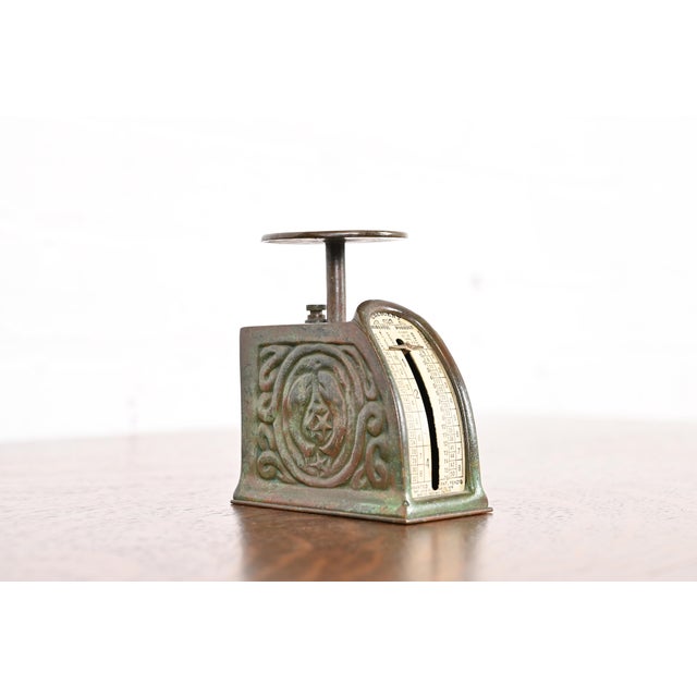 A gorgeous antique Arts & Crafts or Art Deco period bronze postage scale featuring the iconic Zodiac pattern in verdigris...