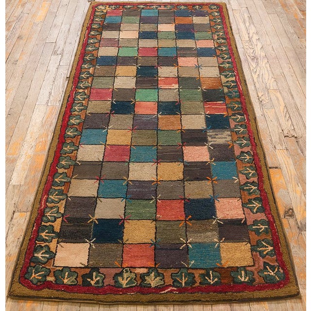 This circa-1880 American hooked rug is a unique piece of folk art featuring a checkerboard pattern with cross-stitched "X"...
