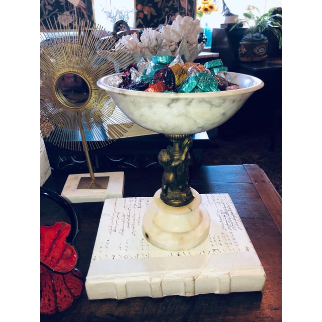 A French marble pedestal with a pair of bronze putti holding the upper bowl. Circa 1880.
