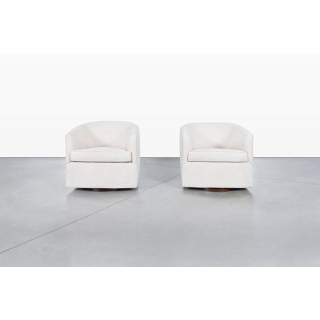 Mid-century modern walnut swivel lounge chairs manufactured in the United States, circa 1960s. Inspired by the timeless...