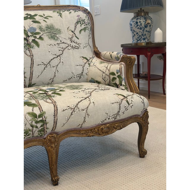 A beautifully restored antique French carved giltwood sofa, reimagined in Thibaut Katsura in Lavender and sumptuous...
