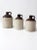 This is a collection of three antique stoneware crock jugs. These antique utilitarian pieces are beautiful statements in...
