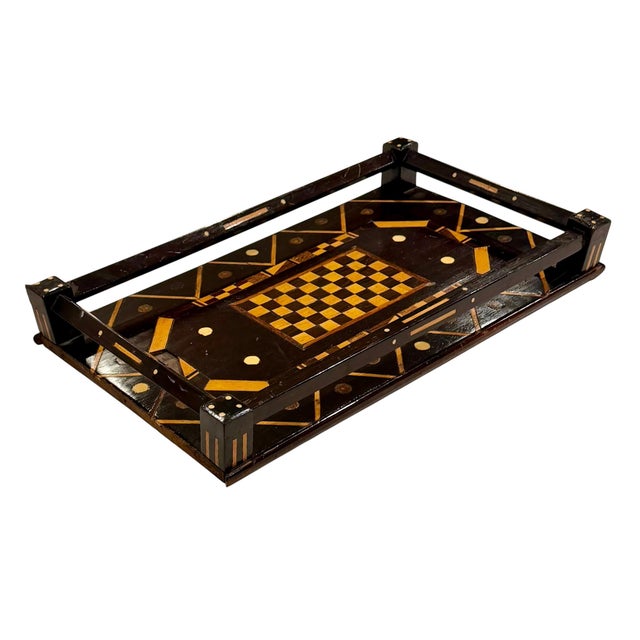 An unusual late 19th century games tray featuring a central checkerboard surrounded by geometric inlay. The dark ground is...