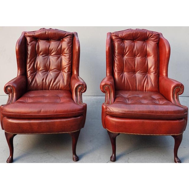 A distinguished pair of Classic Leather Furniture wingback library lounge chairs, expertly handcrafted in the United...