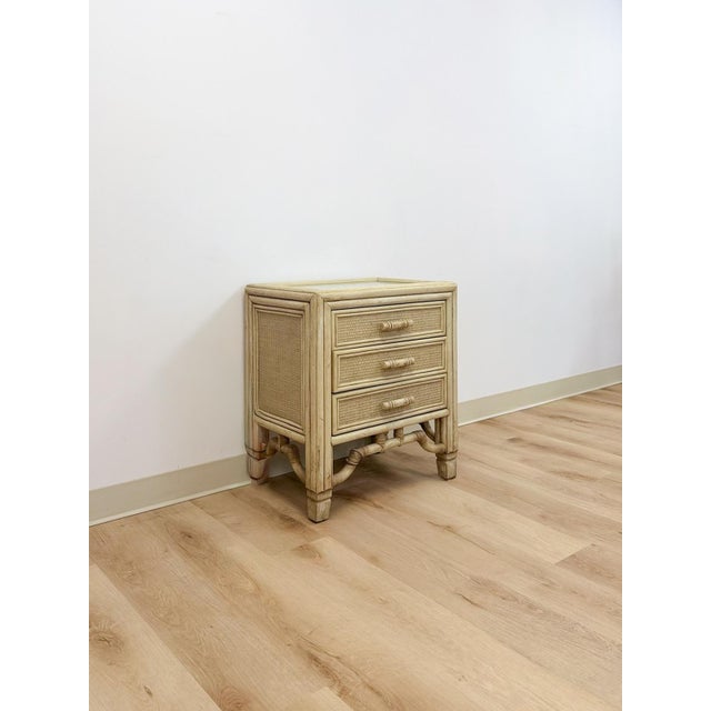 This lovely vintage Ficks Reed style faux bamboo nightstand is a warm and beautifully crafted coastal and Hollywood...
