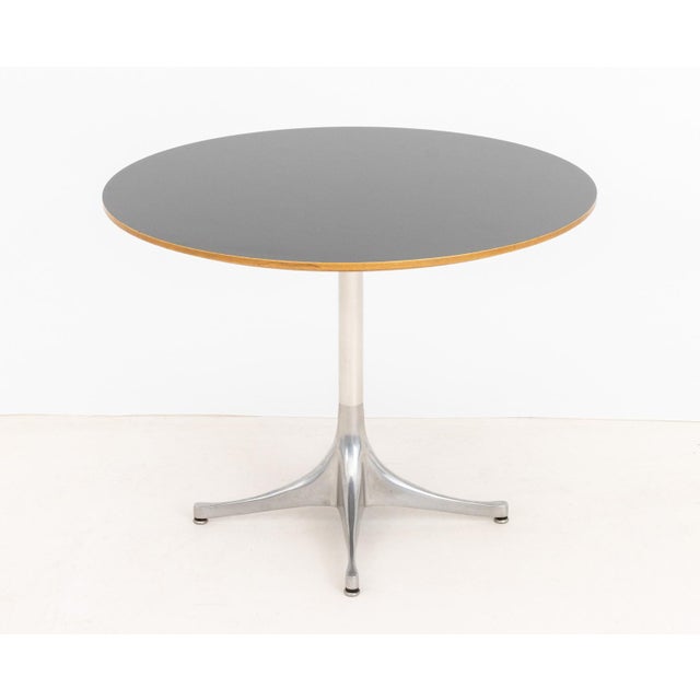 George Nelson for Herman Miller Pedestal Table, black veneered maple top above aluminum base, partial Herman Miller label...