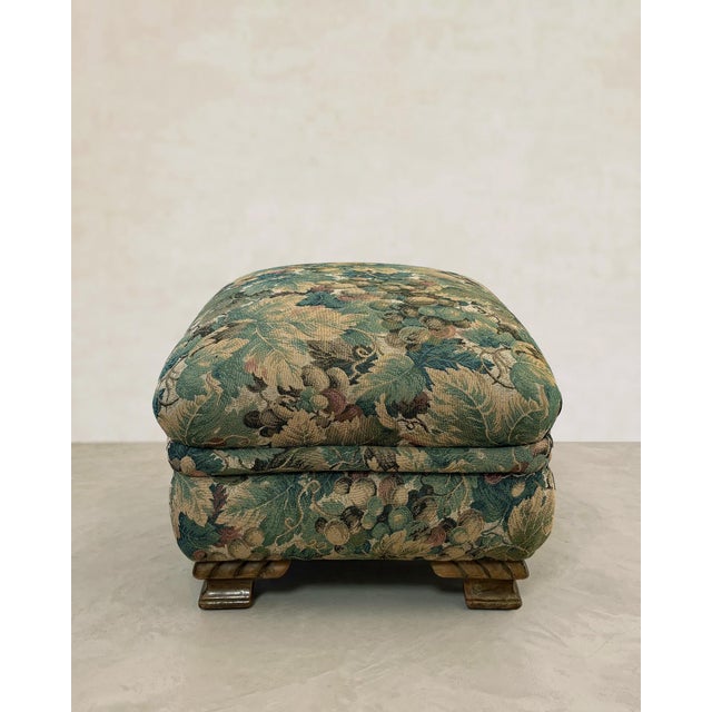 Late 20th-century vintage ottoman on carved hardwood bracket feet. Features a dense verdure tapestry weave in the style of...