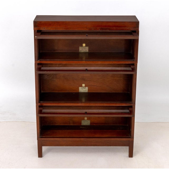 Globe-Wernicke Three Section Walnut Barrister Bookcase, each with glass paneled door and label inside. Overall: 49.5" H x...