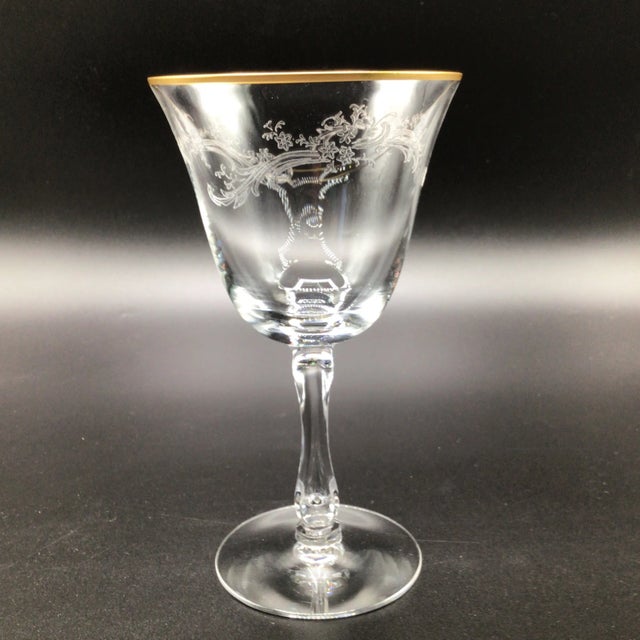 Fostoria water goblets have an etched floral pattern with a gold rim and fluted stem.