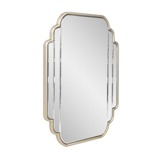 The Winton Vanity Mirror features scalloped edges framed in a champagne silver finish and has a beveled design on the...