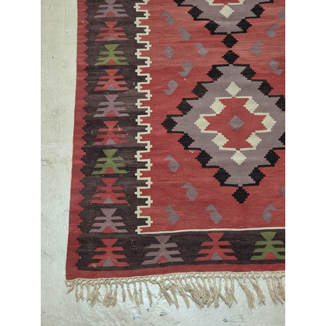 vintage-style Turkish kilim runner rug features a striking geometric tribal design with five large diamond medallions...