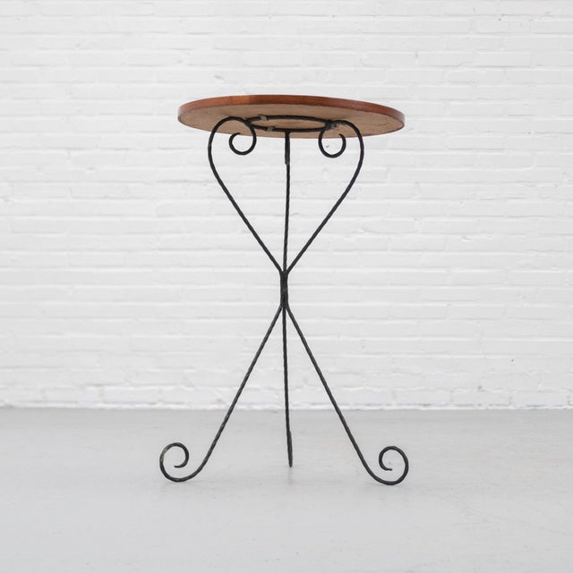 Charming French side table from the 1960s/70s with a slender wrought iron base and round wooden top. The black-finished...