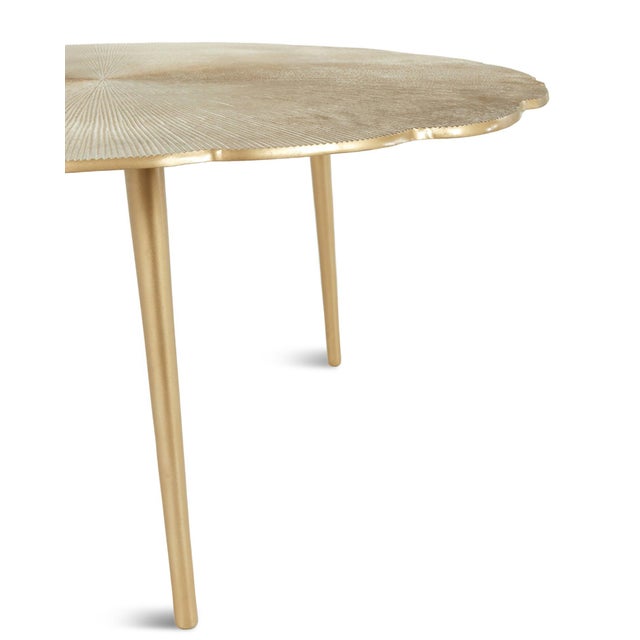 Beautiful warm brass finish aluminum coffee table featuring an energetic chic sunburst textured design across the round...