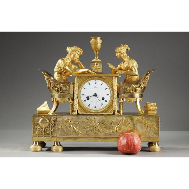 A mercury gilt bronze clock depicting two young women dressed in antique style sitting in Etruscan-style shepherdesses on...