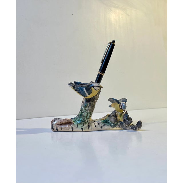 A naturalistic pen-holder in the shape of this glazed ceramic micro cosmos with a blue tit family (parus caeruleus) going...