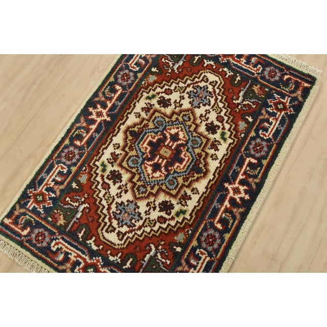 A traditional tribal Heriz rug hand-knotted with fine wool on a cotton foundation. This oriental rug features a central...