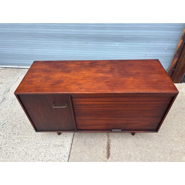 Jens Risom Tambour Door Credenza. Walnut Cabinet with one door to left and Vertical sliding Door on right. Both open to...