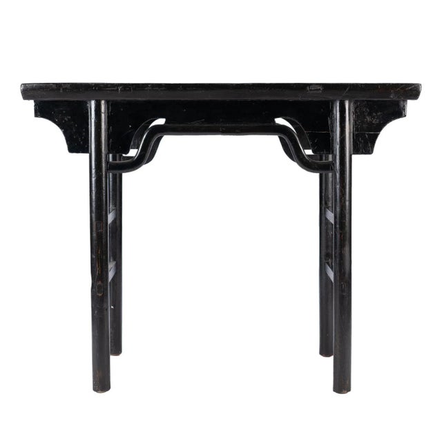Black lacquered elm wood wine table with articulated hump back “bridge” apron rail. Chinese, Kuang Hsu Period, circa 1875.