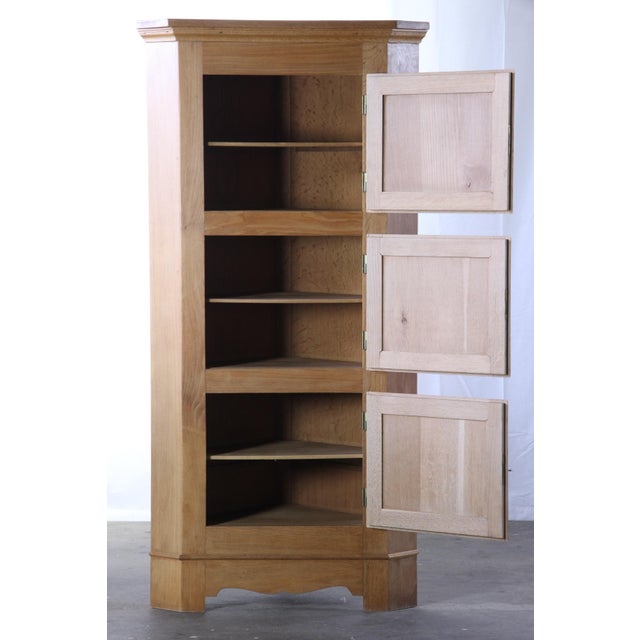 A striking 1960s Danish Mid-Century Modern light oak corner cabinet, in the style of Henning Kjærnulf, designed to...