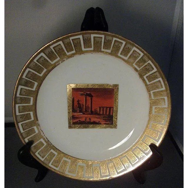 Antique Derby plate decorated with a central reserve of the Roman Forum Ruins in black and bright orange all enhanced with...
