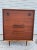 This 4 drawer chest is made of a fine grained Rosewood. The top drawer pulls are inset in rosewood. The chest sits on pair...