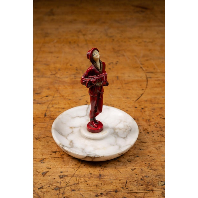 Art Deco figural ashtray attributed to J. B. Hirsch, featuring a cold-painted metal female figure mounted at the center of...